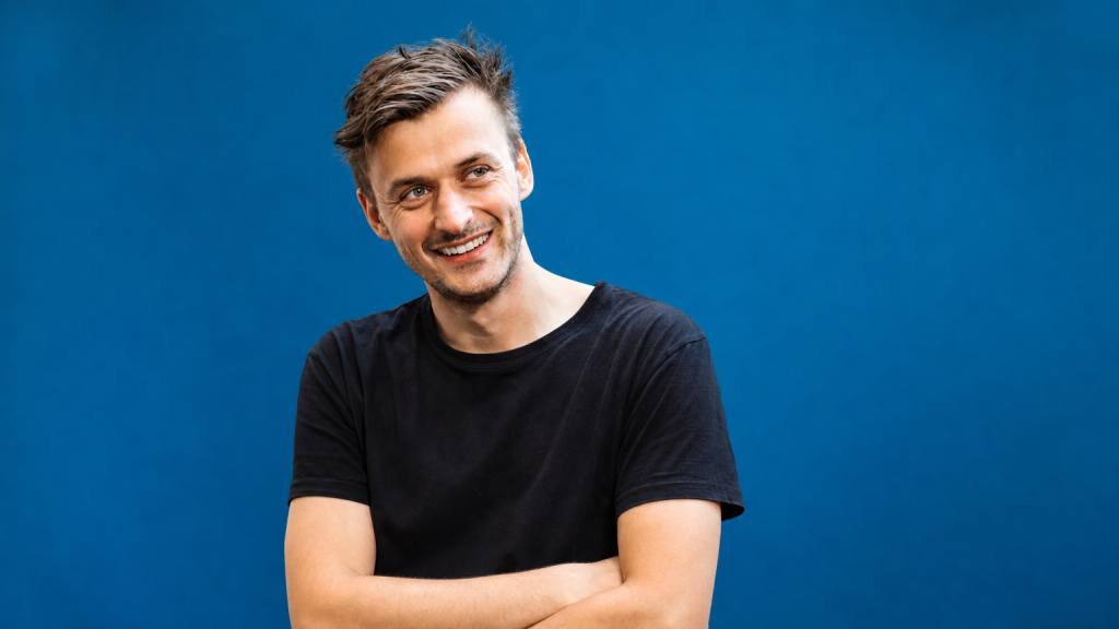 Spokojený pacient s přirozeným úsměvem po zavedení zubního implantátu v moderní ordinaci